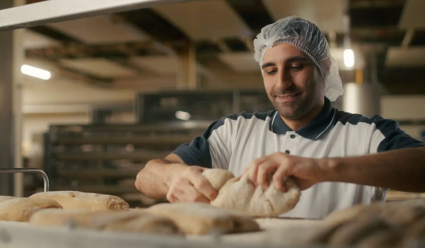 Bäcker, der Teig knetet.